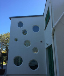 An image of a house we plastered which has interesting round windows